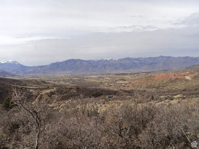 Expansive mountain landscape featuring distant snow-capped peaks and a broad valley