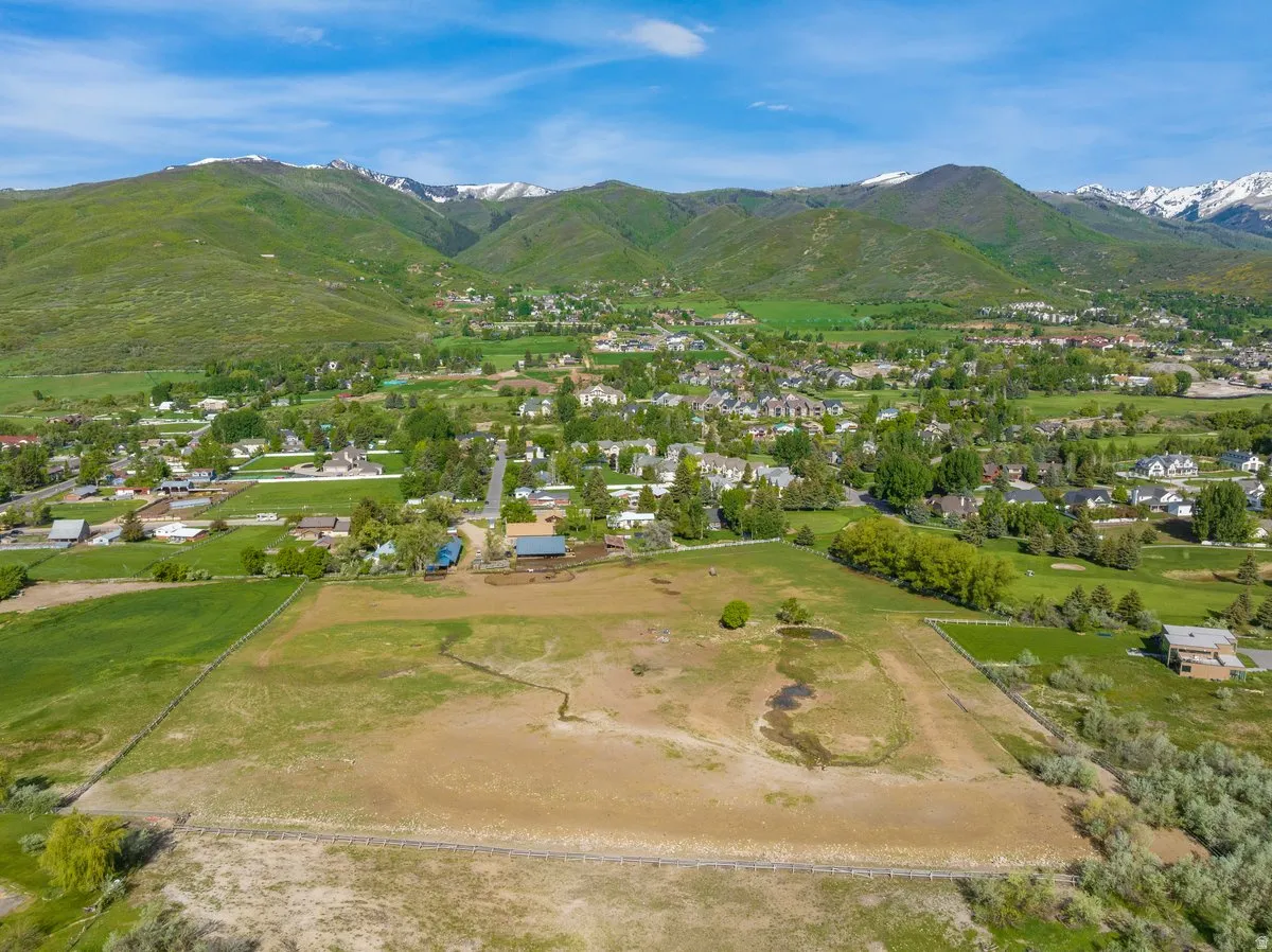 Expansive rural landscape featuring a large, fenced parcel with varied terrain