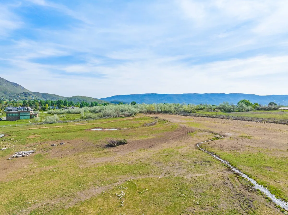 Expansive green acreage with distant mountain ranges and a winding irrigation ditch
