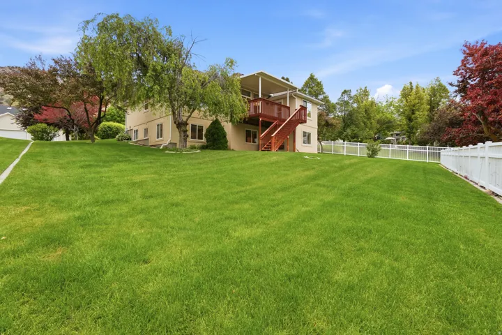 Expansive grassy yard surrounding a two-story residence with a beige exterior
