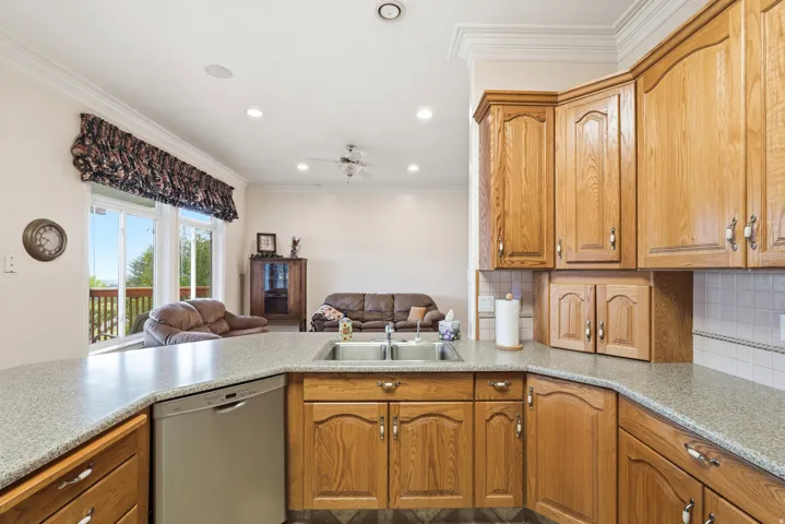 Kitchen featuring wood cabinetry, speckled countertops, and a double basin sink