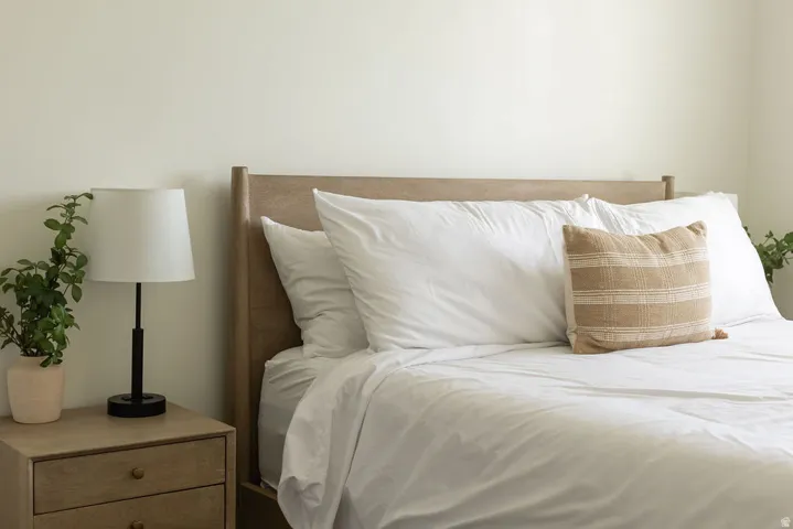 Light-toned wood-finish headboard and nightstand with two drawers, complemented by a solid wall color
