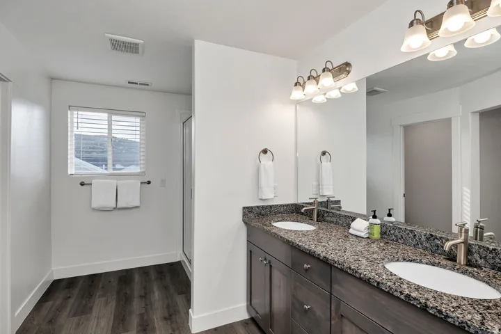 Dual sink vanity featuring a speckled countertop, undermount sinks, and brushed nickel fixtures