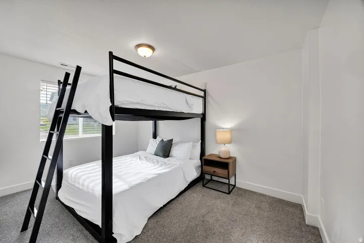 Neutral interior with carpet flooring, white walls, and a single ceiling light fixture
