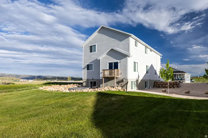 Expansive green lawn surrounding a modern residence with light gray siding