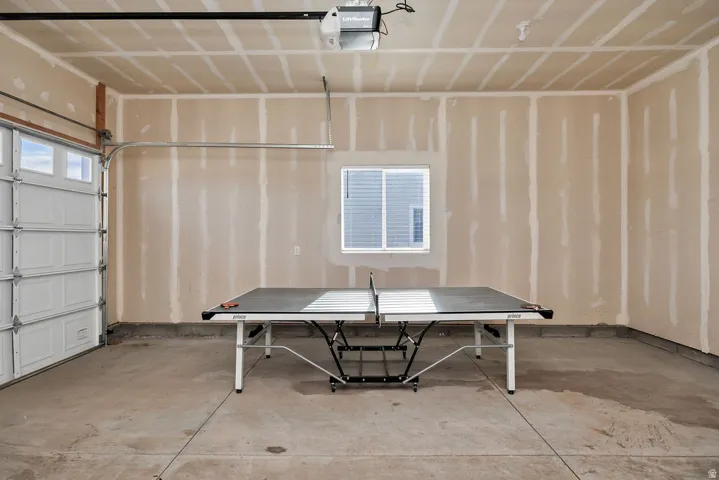 Spacious garage featuring a concrete floor, overhead door, and an automatic garage door opener