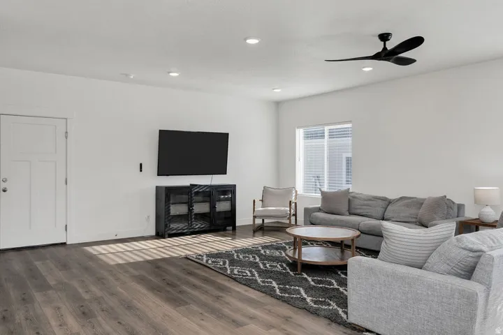 Spacious living area featuring wood-finish flooring, recessed lighting, and a contemporary ceiling fan