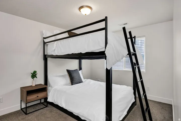 Bedroom featuring a window with blinds, a flush mount ceiling light, and neutral carpet flooring