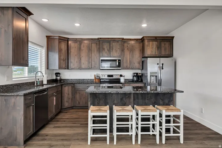 Contemporary kitchen featuring wood-finish cabinetry and dark stone countertops