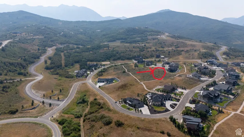 Expansive mountainous landscape with paved roads and scattered residential properties
