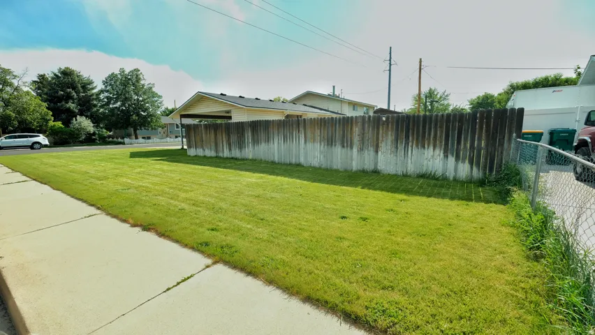 Expansive front lawn with established landscaping and concrete sidewalk