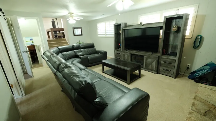 Carpeted recreation room featuring white walls and a built-in entertainment center