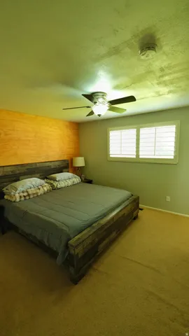 Bedroom featuring a wood-finish accent wall and carpet flooring