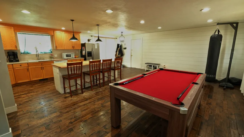 Open-concept living space featuring wood-finish flooring, recessed lighting, and a neutral color palette