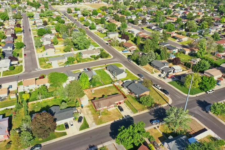 Expansive aerial capturing a residential neighborhood with numerous single-story homes and mature landscaping