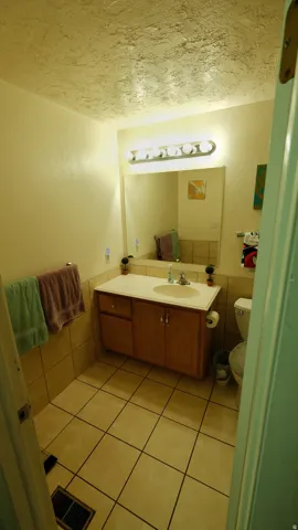 Bathroom featuring a vanity with a laminate countertop, integrated sink, and wood cabinetry