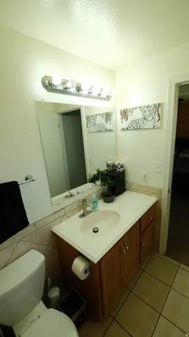 Bathroom vanity with a light wood-finish cabinet, white countertop, and integrated oval sink
