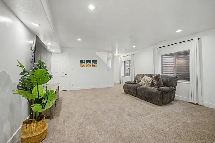 Spacious room featuring neutral carpeting, recessed lighting, and white walls