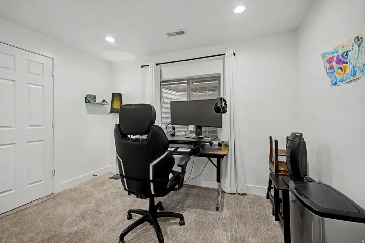 Carpeted room with a double-panel interior door, recessed lighting, and a window with white curtains