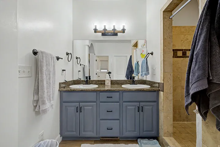 Double vanity with dark countertops, dual undermount sinks, and matte black fixtures