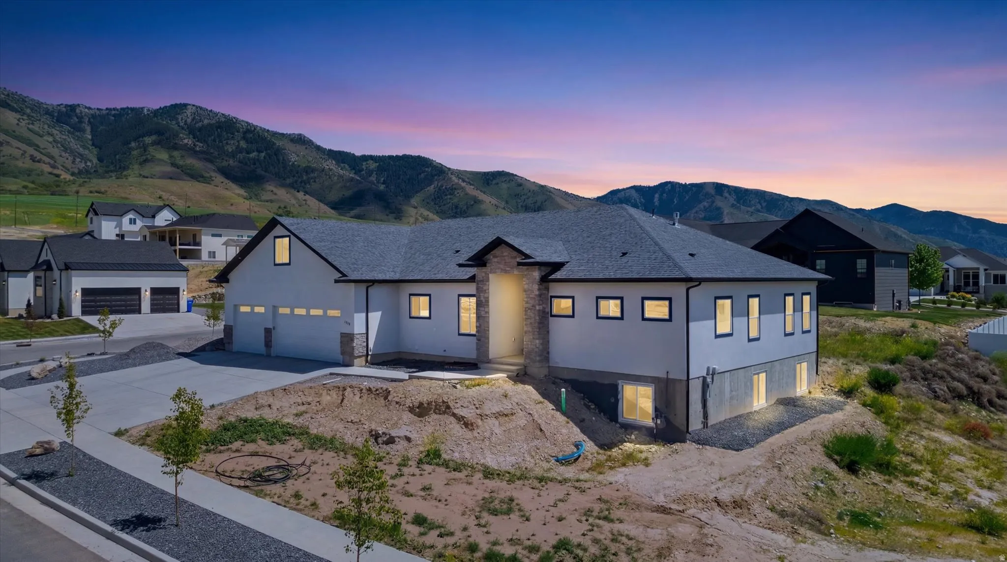 Modern home exterior featuring a dark grey shingle roof and light-colored siding