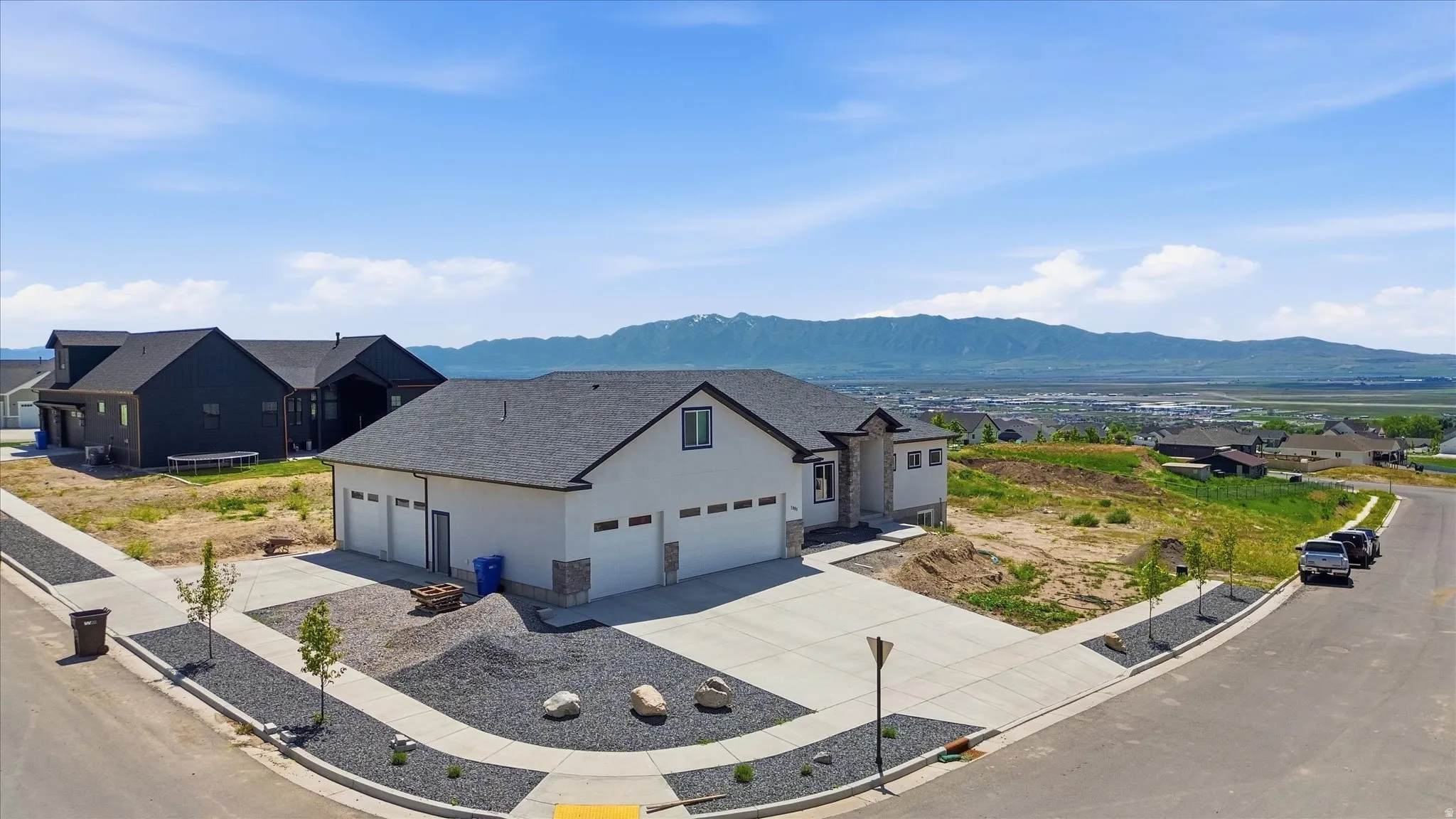 Corner lot.   Lots of parking.   Modern single-story residence with a white stucco exterior and stone accents