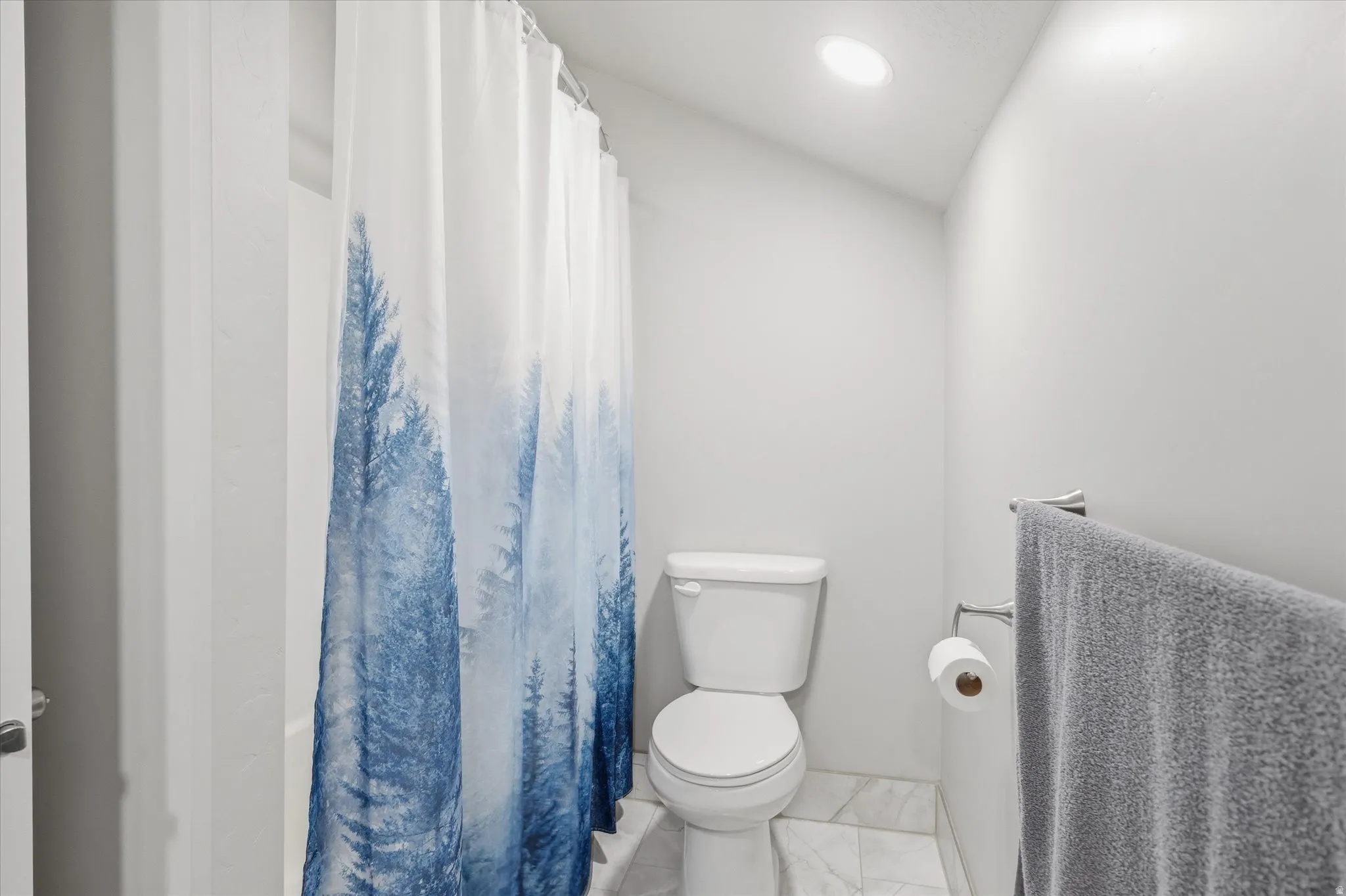 Bathroom featuring a white toilet, recessed lighting, and a white bathtub with shower