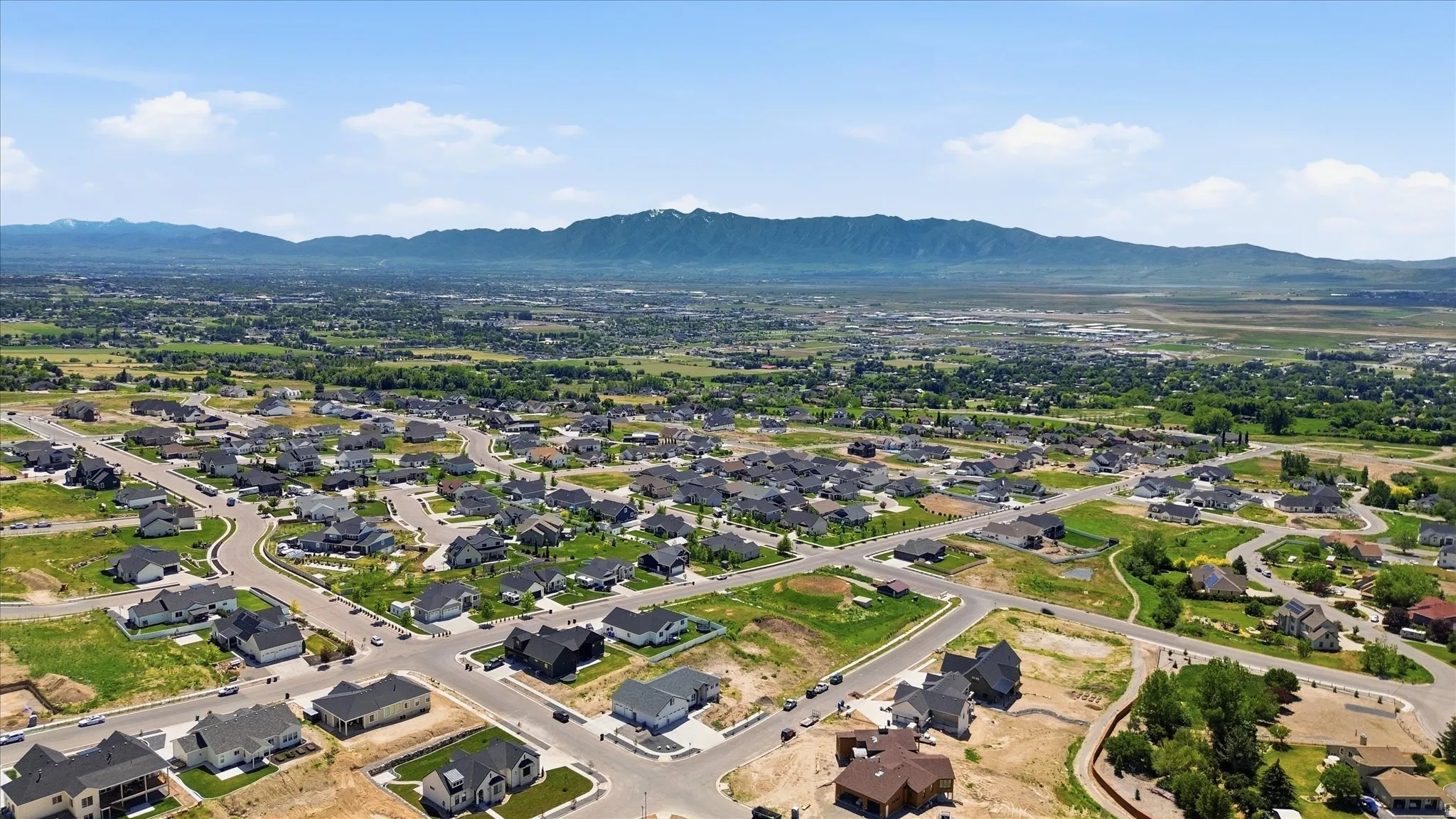 Aerial perspective showcasing a residential community with mature landscaping and mountain scenery