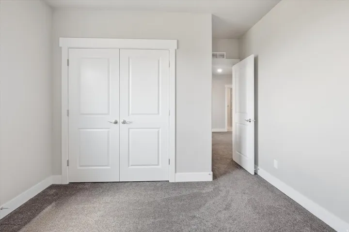 Neutral gray wall paint with white trim, gray carpet, and white paneled doors