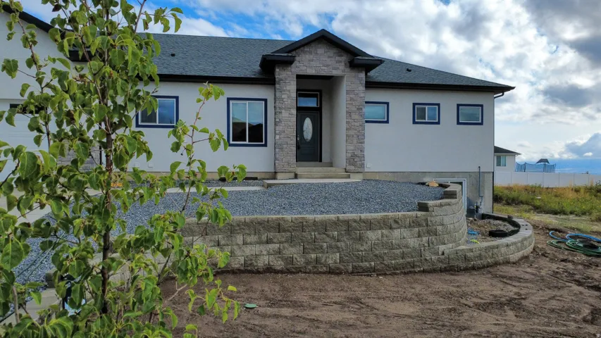 Stucco exterior with stone accents and dark trim windows