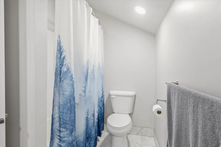 Bathroom featuring a white toilet, recessed lighting, and a white bathtub with shower