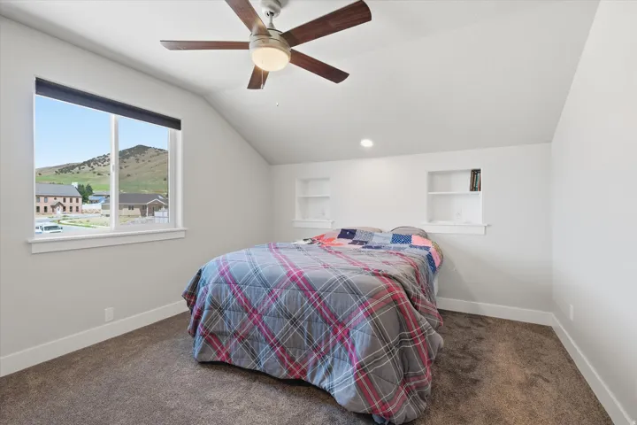 Bedroom featuring a vaulted ceiling with a ceiling fan, recessed lighting, and built-in shelving