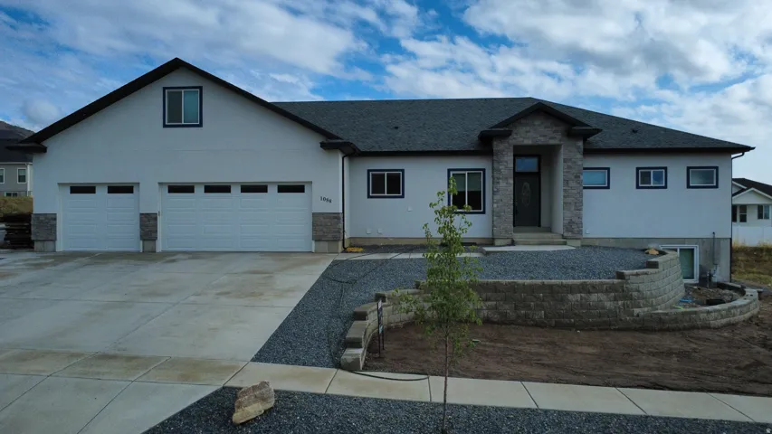 Contemporary exterior with a stone-clad entry, stucco siding, and a dark shingle roof