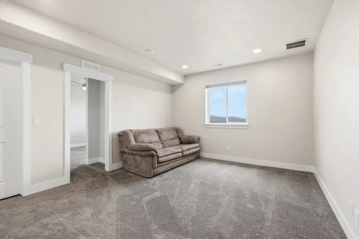 Neutral painted walls complement the grey carpeted flooring throughout this space