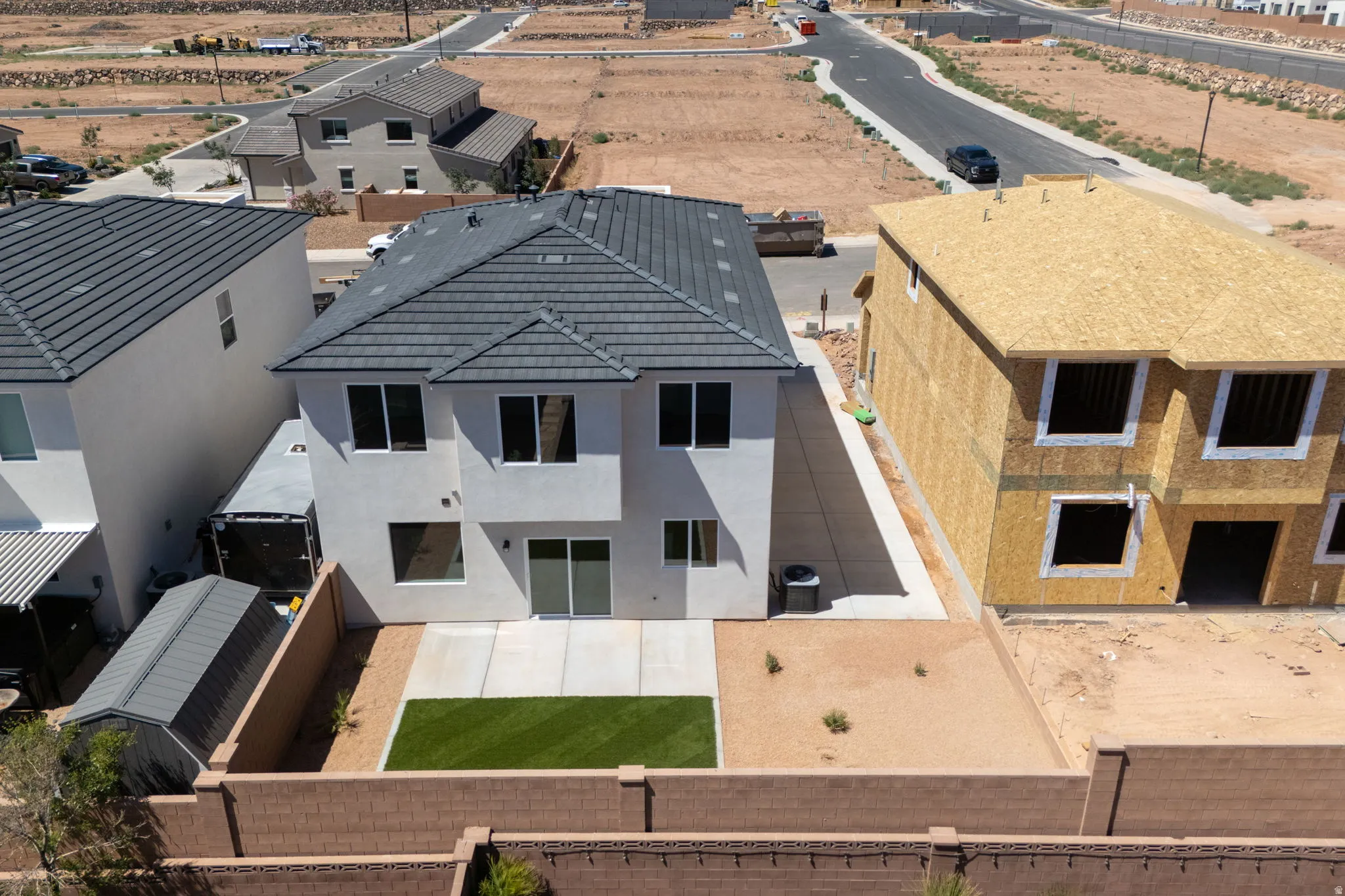 Contemporary two-story stucco exterior featuring a dark tile roof