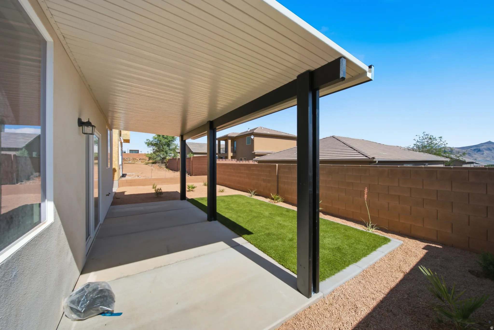 Expansive covered patio featuring a smooth concrete slab and recessed lighting