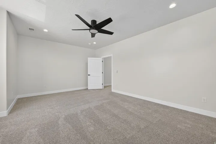 Spacious interior room featuring light gray carpeting and white baseboards