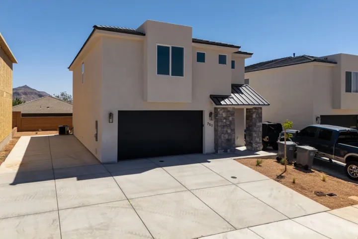 Contemporary stucco exterior featuring a flat roofline and dark framed windows