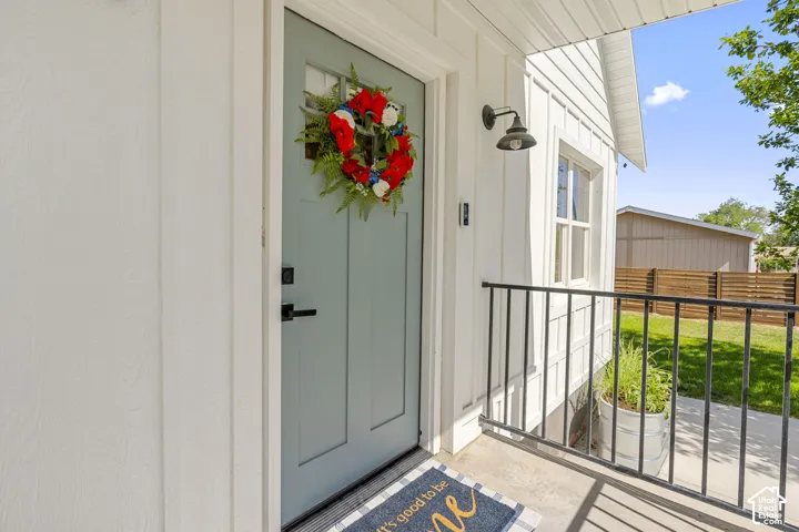 Light blue paneled entry door with transom window, complemented by white board and batten siding