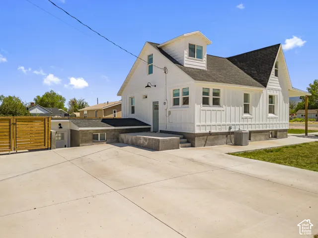 White exterior siding, black shingle roof, and multiple windows