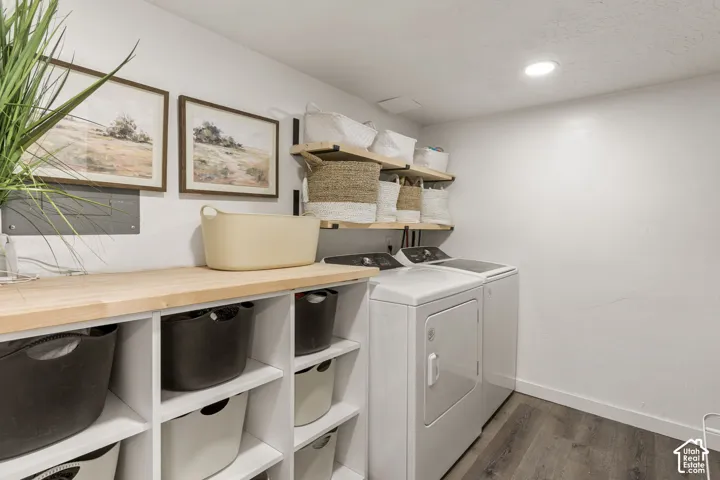 Dedicated laundry area featuring wood-finish flooring and recessed lighting