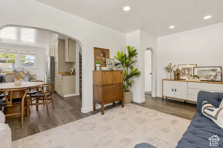 Living area featuring wood-finish flooring, recessed lighting, and arched doorways