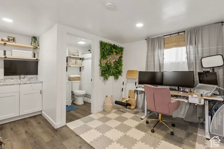 Versatile room featuring wood-finish flooring and recessed lighting