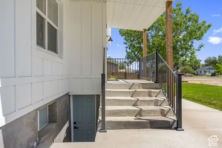 Covered front porch with wood columns and black railings
