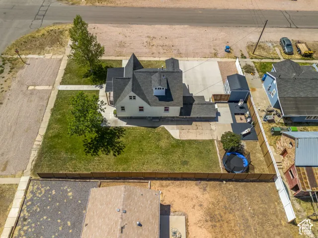Aerial perspective showcasing the property's exterior, featuring a gabled roofline, detached shed, and fenced backyard