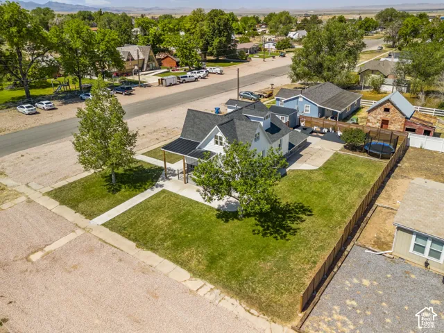 White exterior property featuring a dark metal roof, covered front porch, and a concrete pathway