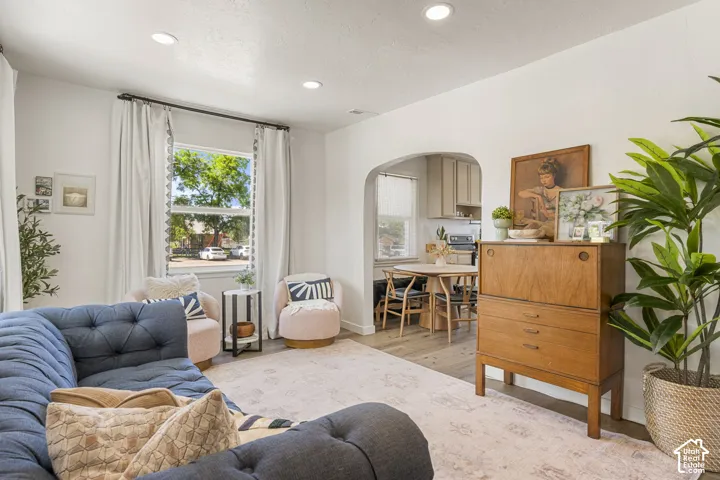 Bright living area featuring recessed lighting, a large window with white trim, and light wood-finish flooring