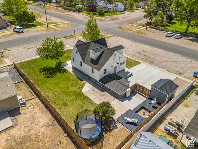 White-sided residence with black roof accents, featuring a generous concrete driveway and a manicured lawn