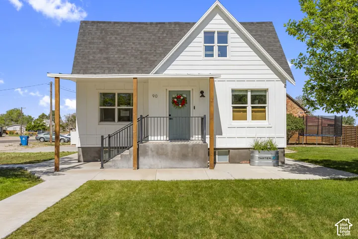 White farmhouse-style exterior with a gable roof and dark shingle siding