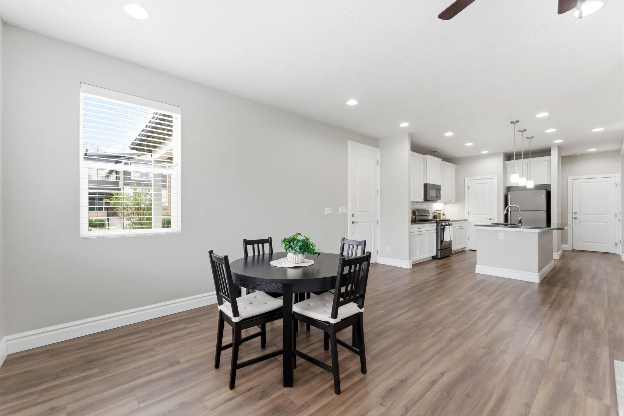 Open-concept living space featuring wood-finish flooring, recessed lighting, and a modern kitchen